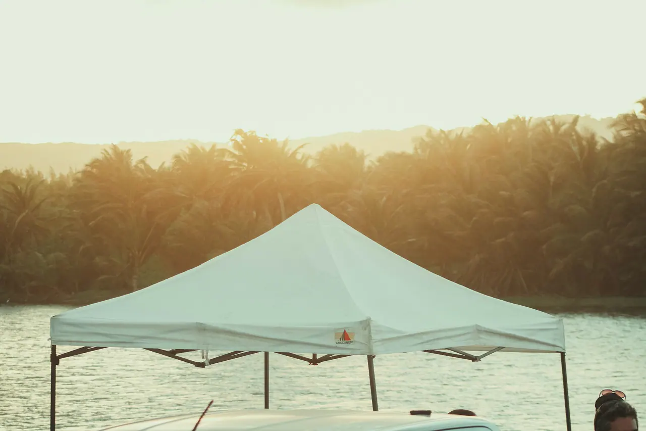 White canopy tent beside calm water