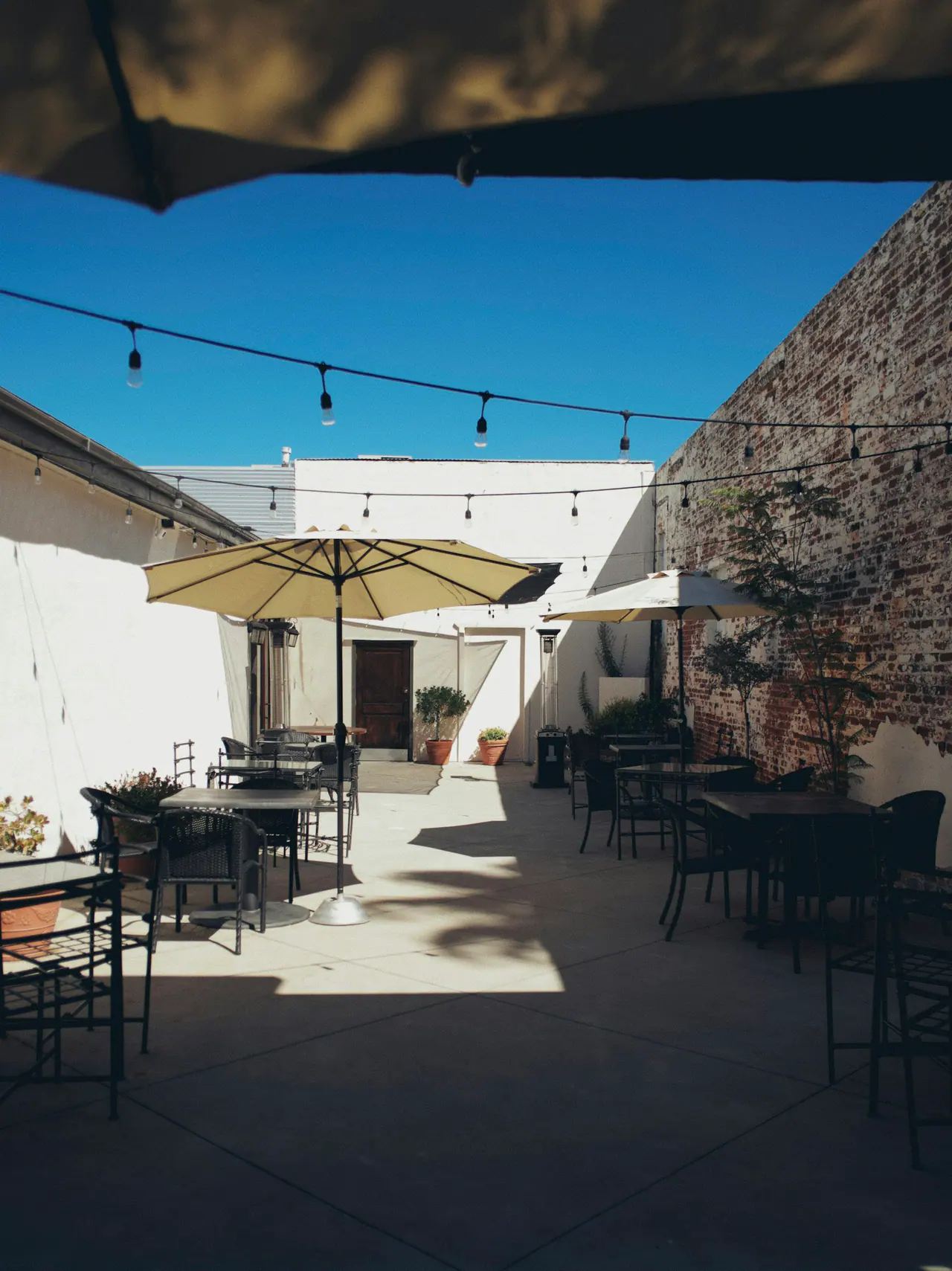 Warm-toned umbrellas in a sunlit courtyard